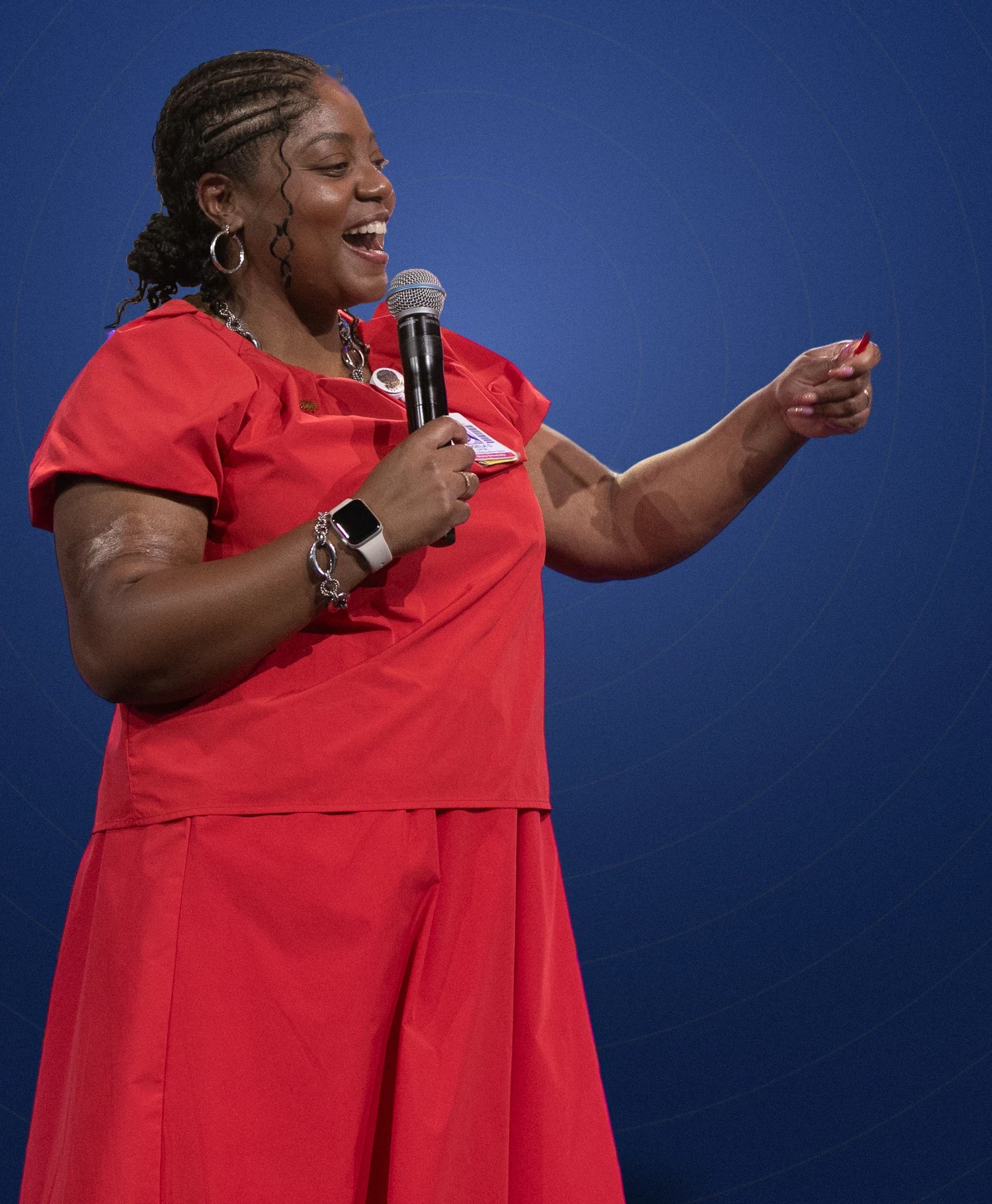 Angela on stage with a microphone, mid-keynote
